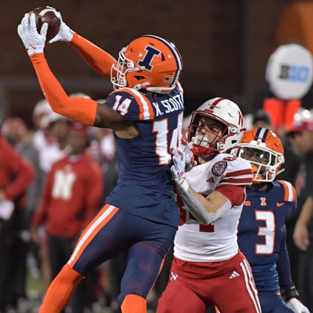  Illinois Fighting Illini defensive back Xavier Scott (14) intercepts the ball in front of intended Nebraska Cornhuskers wide