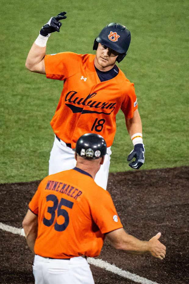 Auburn Tigers catcher Ike Irish (18) celebrates with associate coach Karl Nonemaker (35) as he rounds third base to head home