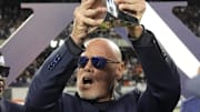 Sep 8, 2025; Chicago, Illinois, USA; Former Chicago Bear quarterback Jim McMahon holds the Super Bowl Twenty trophy during half time at Soldier Field. Mandatory Credit: David Banks-Imagn Images