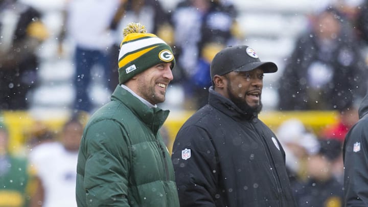 Green Bay Packers quarterback Aaron Rodgers and Pittsburgh Steelers head coach Mike Tomlin talk during warmups prior to the game at Lambeau Field.