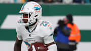 Jan 5, 2025; East Rutherford, New Jersey, USA; Miami Dolphins running back De'Von Achane (28) runs with the ball during the first quarter of their game against the New York Jets at MetLife Stadium. Mandatory Credit: Ed Mulholland-Imagn Images