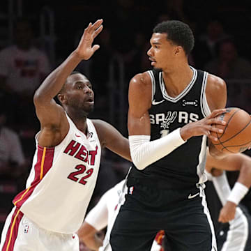 Oct 8, 2025; Miami, Florida, USA;  San Antonio Spurs center Victor Wembanyama (1) looks to pass as Miami Heat forward Andrew Wiggins (22) defends in the first half at Kaseya Center. Mandatory Credit: Jim Rassol-Imagn Images