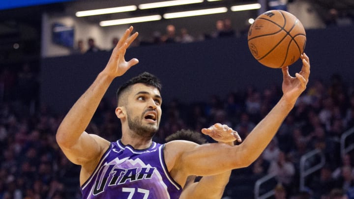 Apr 14, 2024; San Francisco, California, USA; Utah Jazz center Omer Yurtseven (77) grabs a rebound in front of Golden State Warriors forward Trayce Jackson-Davis during the first quarter at Chase Center. Mandatory Credit: D. Ross Cameron-USA TODAY Sports