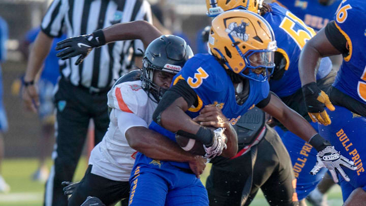 Lakeland linebacker Ziggy Riley tackles Miami Northwestern running back Ryan Mathis on Saturday night in the Kickoff Classic at Vero Beach High School. Lakeland linebacker Ziggy Riley tackles Miami Northwestern running back Ryan Mathis on Saturday night in the Kickoff Classic at Vero Beach High School.