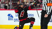 Jan 5, 2025; Raleigh, North Carolina, USA;  Carolina Hurricanes defenseman Jalen Chatfield (5) celebrates his goal against the Pittsburgh Penguins during the second period at Lenovo Center. Mandatory Credit: James Guillory-Imagn Images