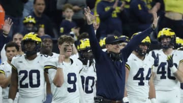 Michigan quarterback J.J. McCarthy (9) and coach Jim Harbaugh celebrate after U-M's 26-0 win over
