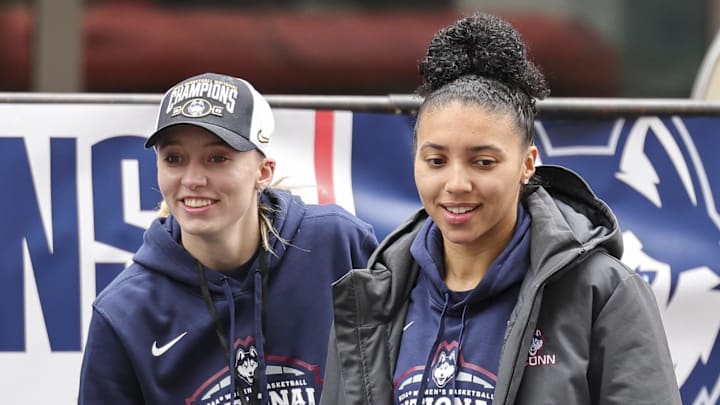 Apr 13, 2025; Hartford, CT, USA;  UConn student-athlete Paige Bueckers and UConn student-athlete Azzi Fudd walk onto the stage during the Final Four Champions victory parade and rally outside of the XL Center in Hartford, CT. Mandatory Credit: Scott Rausenberger-Imagn Images