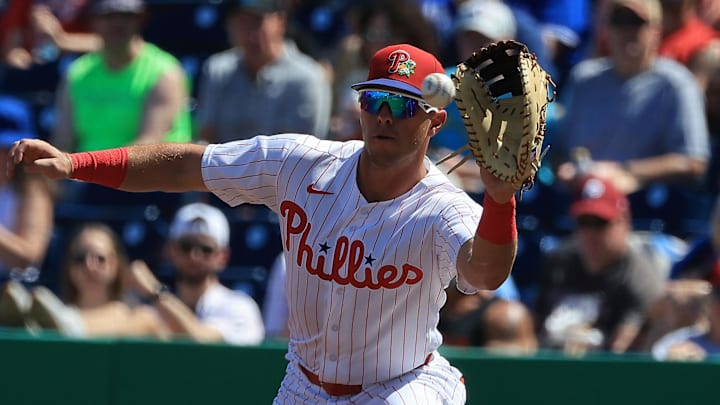 Mar 7, 2026; Clearwater, Florida, USA;  Philadelphia Phillies first baseman Dylan Moore (25) catches the ball at first base for an out during the first inning against the Toronto Blue Jays at BayCare Ballpark. Mandatory Credit: Kim Klement Neitzel-Imagn Images