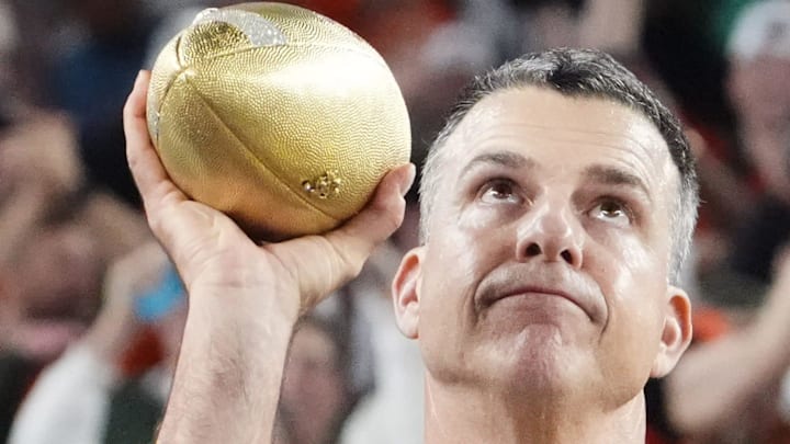 Miami Hurricanes head coach Mario Cristobal lifts a trophy after advancing to the College Football Playoff final.