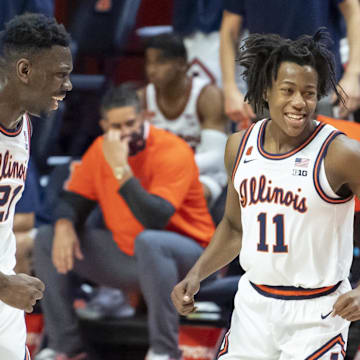 Jan 2, 2021; Champaign, Illinois, USA; Illinois Fighting Illini center Kofi Cockburn (21) and guard Ayo Dosunmu (11) celebrate during the first half against the Purdue Boilermakers at the State Farm Center. Mandatory Credit: Patrick Gorski-Imagn Images
