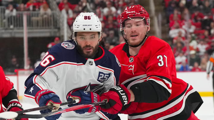 Dec 9, 2025; Raleigh, North Carolina, USA;  Carolina Hurricanes right wing Andrei Svechnikov (37) and Columbus Blue Jackets right wing Kirill Marchenko (86) watch the play during the second period at Lenovo Center. Mandatory Credit: James Guillory-Imagn Images