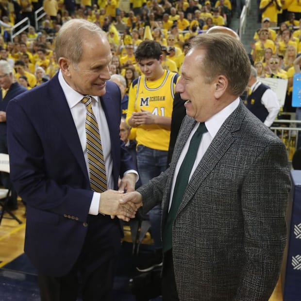 Former Michigan men's basketball head coach John Beilein speaks with Michigan State's Tom Izzo