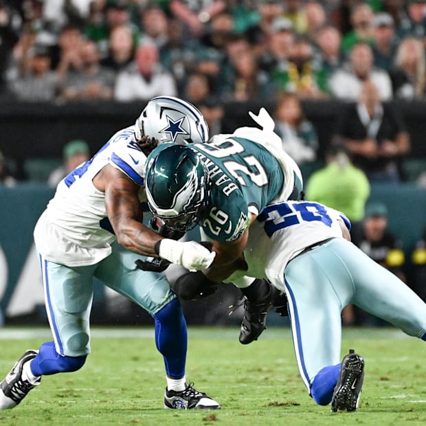 Philadelphia Eagles RB Saquon Barkley is tackled by Dallas Cowboys DE Sam Williams and CB Kaiir Elam.