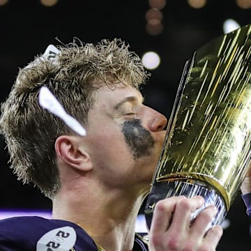 Michigan quarterback J.J. McCarthy kisses the trophy to celebrate winning the national championship game.