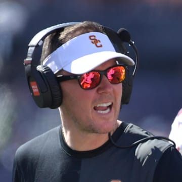 Sep 27, 2025; Champaign, Illinois, USA;  Southern California Trojans head coach Lincoln Riley talks with players during the first half against the Illinois Fighting Illini  at Memorial Stadium. Mandatory Credit: Ron Johnson-Imagn Images