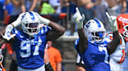 Sep 6, 2025; Durham, North Carolina, USA;  Duke Blue Devils cornerback Chandler Rivers (0), linebacker Jaiden Francois (2) and cornerback Kimari Robinson (5) celebrate a tackle by defensive end Vincent Anthony Jr.'s (7) against the Illinois Fighting Illini during the first quarter at Wallace Wade Stadium. Mandatory Credit: Zachary Taft-Imagn Images