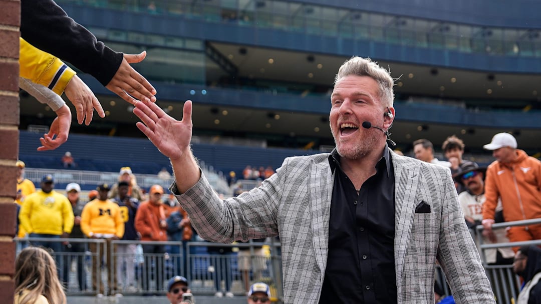 ESPN College Game Day's Pat McAfee high-fives fans as he takes the field before the game between Michigan and Texas at Michigan Stadium in Ann Arbor on Saturday, September 7, 2