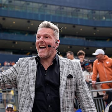 ESPN College Game Day's Pat McAfee high-fives fans as he takes the field before the game between Michigan and Texas at Michigan Stadium in Ann Arbor on Saturday, September 7, 2