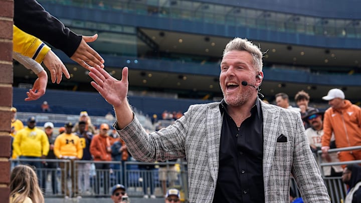 ESPN College Game Day's Pat McAfee high-fives fans as he takes the field before the game between Michigan and Texas at Michigan Stadium in Ann Arbor on Saturday, September 7, 2