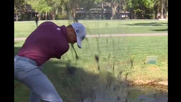 Justin Thomas hits a ball out of muddy water at the RBC Heritage.
