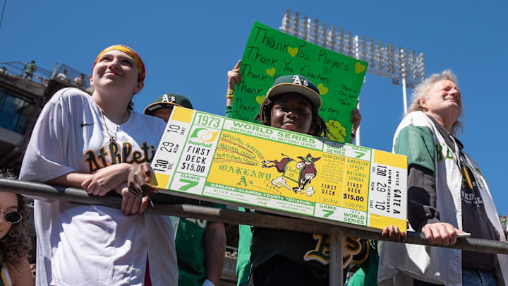 A’s fans hold up signs before the team’s final game at Oakland-Alameda County Coliseum.