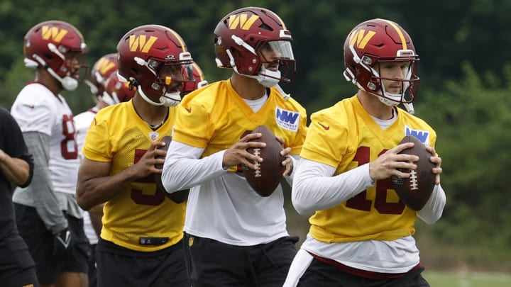 Jun 5, 2024; Ashburn, VA, USA; Washington Commanders quarterback Jeff Driskel (16), Commanders quarterback Marcus Mariota (0), and Commanders quarterback Jayden Daniels (5) prepare to pass a ball during OTA workouts at Commanders Park. Mandatory Credit: Geoff Burke-USA TODAY Sports