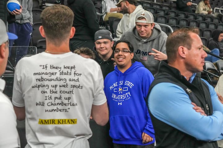McNeese State student manager Amir Khan takes photos with fans before the NCAA Tournament. 