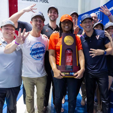 UVA athletics director Carla Williams and the Virginia swim & dive coaching staff pose with the 2024 NCAA Women's Swim & Dive National Championship trophy.