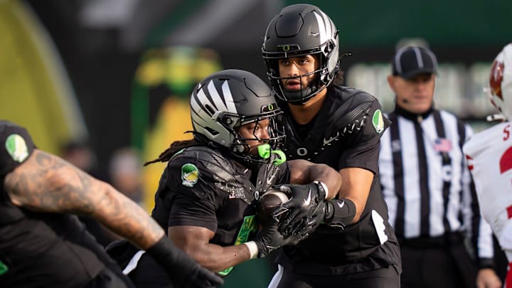 Oregon quarterback Dante Moore, right, hands off the ball to running back Noah Whittington as the Oregon Ducks host the Wisconsin Badgers on Oct. 25, 2025, at Autzen Stadium in Eugene, Oregon.