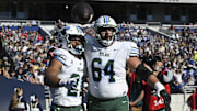 Nov 16, 2024; Annapolis, Maryland, USA; Tulane Green Wave running back Makhi Hughes (21) celebrates with offensive lineman Vincent Murphy (64) after scoring a touchdown against the Navy Midshipmen at Navy-Marine Corps Memorial Stadium. 