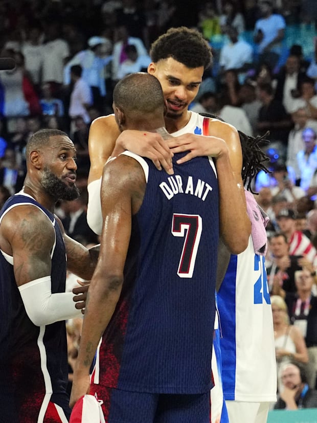 United States guard Kevin Durant (7) embraces France power forward Victor Wembanyama (32) after the men's basketball gold med