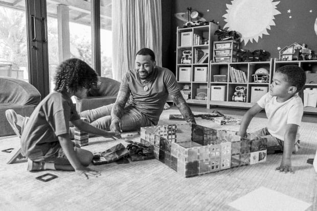 John Wall sits in the living room with both of his sons, Ace and Amir, while playing with Magna-Tiles.