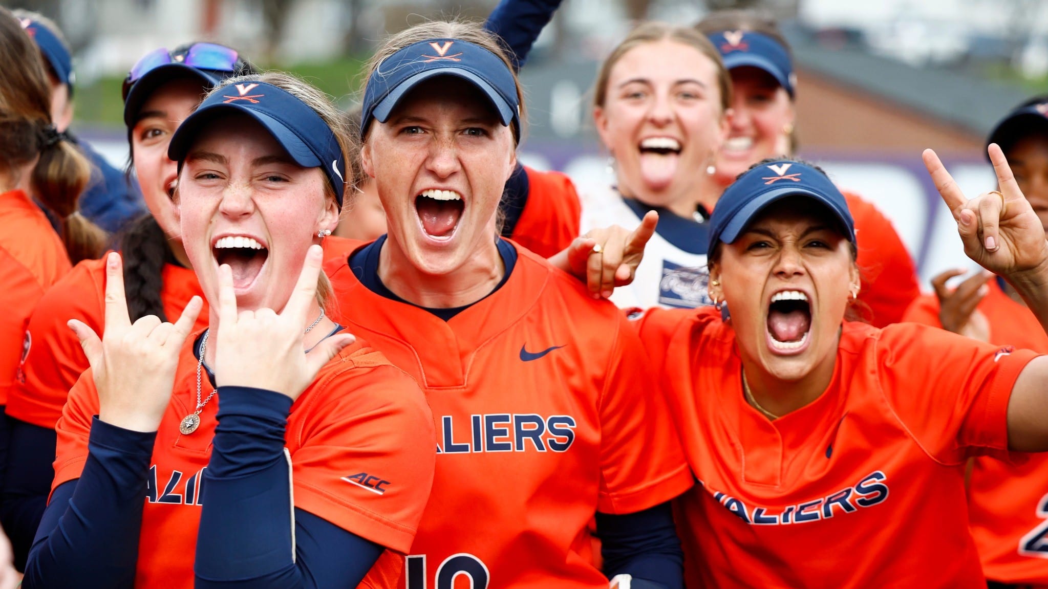 Reece Holbrook, Jade Hylton, and Abby Weaver celebrate after the Virginia softball team's victory at James Madison.