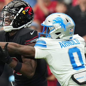 Cardinals receiver Marvin Harrison Jr. (18) tries to catch the ball as Lions cornerback Terrion Arnold (0) defends 