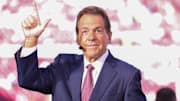 ESPN personality Nick Saban does the Guns Up gesture