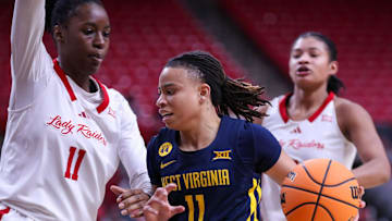West Virginia's JJ Quinerly is met by Texas Tech's Sarengbe Sanogo on a drive to the basket during a Big 12 Conference women's basketball game, Wednesday, Jan. 8, 2025, in United Supermarkets Arena.