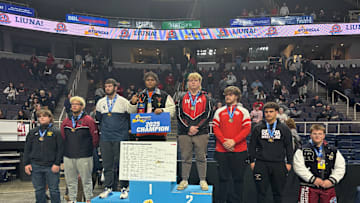Wilson High School senior Hamza Merrick, middle, captured the 285-pound wrestling title at the New York state tournament last weekend.