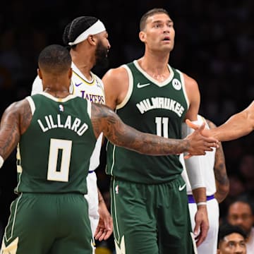 Oct 15, 2023; Los Angeles, California, USA; Milwaukee Bucks forward Giannis Antetokounmpo (34) celebrates with guard Damian Lillard (0) and center Brook Lopez (11) against the Los Angeles Lakers during the first quarter at Crypto.com Arena. Mandatory Credit: Jonathan Hui-Imagn Images
