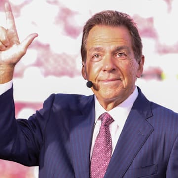 ESPN personality Nick Saban does the Guns Up gesture