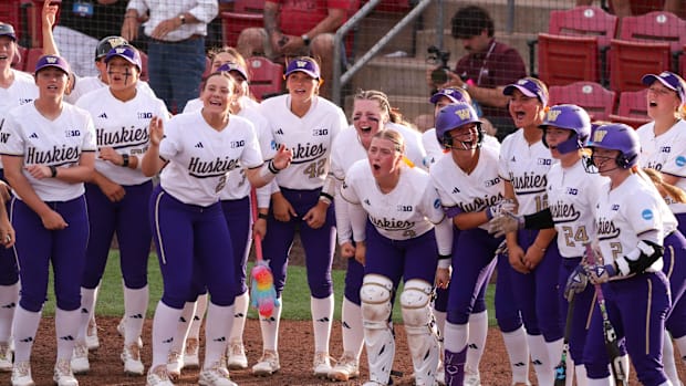 Washington players wait to greet Ava Carroll at home after a home run against Mississippi State in the Lubbock regional.