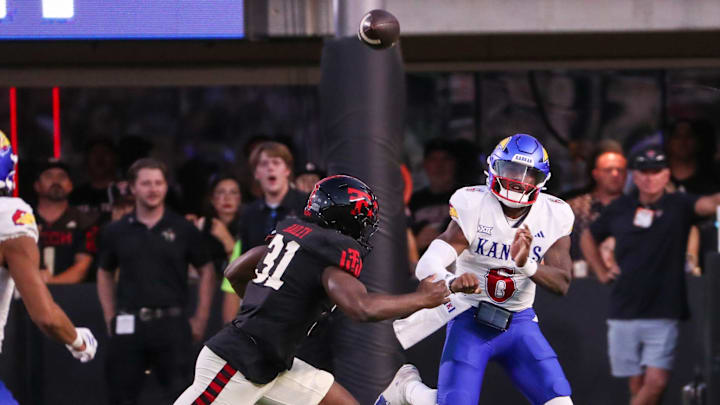 Kansas' Jalon Daniels passes the ball while being pressured by Texas Tech's David Bailey during a Big 12 Conference football game, Saturday, Oct. 11, 2025, at Jones AT&T Stadium in Lubbock.