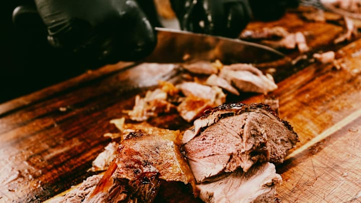 Pitmaster Al Frugoni cuts open a grilled lamb during the second day of the SmokeSlam Barbecue Festival on Friday, May 16, 2025 at Tom Lee Park in Memphis, Tenn.