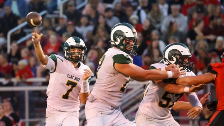 Robert Percha (77) and Carter Aicher (57) block as Flat Rock Graham Junge throws the ball during a 49-21 Flat Rock win over Milan Friday night.