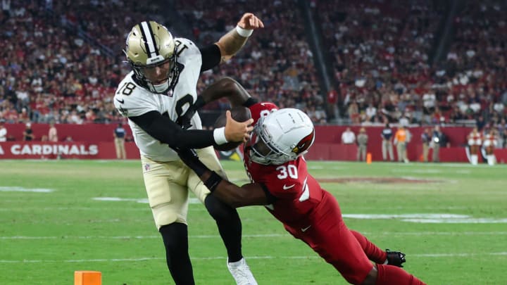 New Orleans Saints quarterback Spencer Rattler (18) reaches for the pylon while being tackled by Arizona Cardinals safety Darren Hall (30) during a preseason game on Aug. 10, 2024 at State Farm Stadium in Glendale.