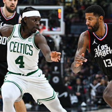 Dec 23, 2023; Los Angeles, California, USA; Los Angeles Clippers forward Paul George (13) moves the ball against Boston Celtics guard Jrue Holiday (4) during the third quarter at Crypto.com Arena. Mandatory Credit: Jonathan Hui-USA TODAY Sports