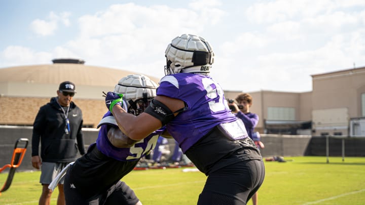 Defensive Coordinator Andy Avalos watches Quinton Harris and Markis Deal during a blocking drill. 