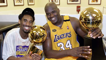 Kobe Bryant (L) of the Los Angeles Lakers holds the NBA Finals trophy