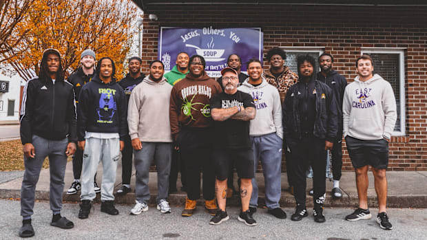 Several members of the East Carolina football team volunteering at a local soup kitchen