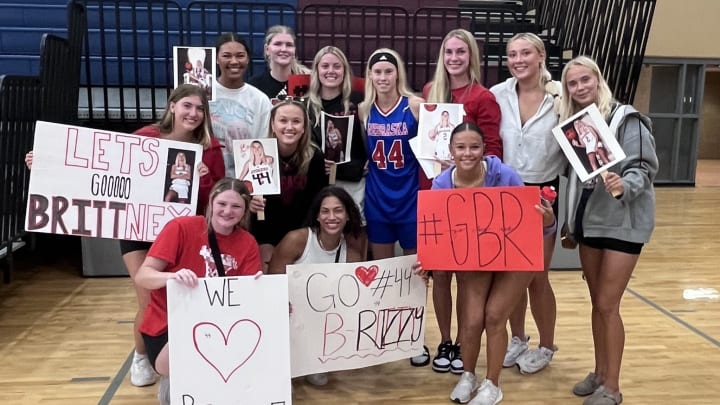 Members of the Nebraska women's basketball team surround Elkhorn North graduate Britt Prince (center, #44) in celebration of her record-breaking night at the NCA All-Star Game. 