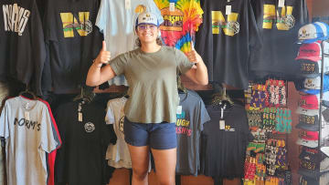 Nebraska volleyball middle blocker Rebekah Allick poses with merch at Norm's on 48th where she will run the register during an upcoming lunch rush.